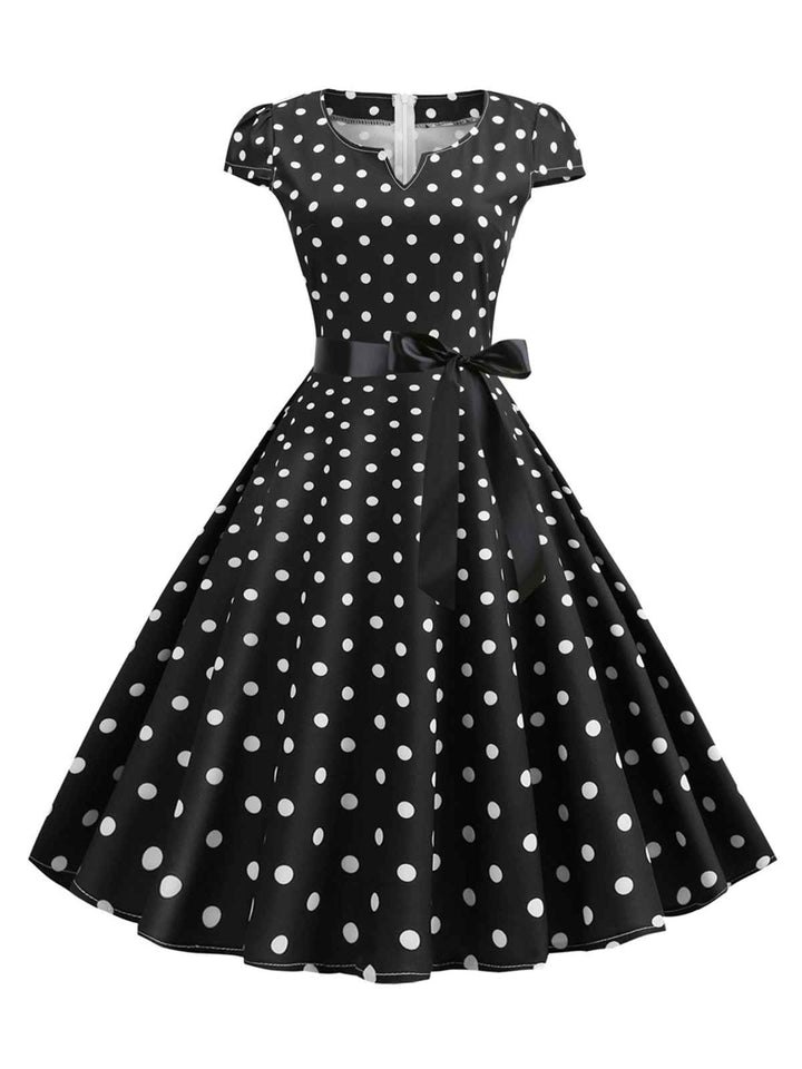 She slips into this 1950s Cap Sleeve Polka Dot Belted Dress and suddenly it&