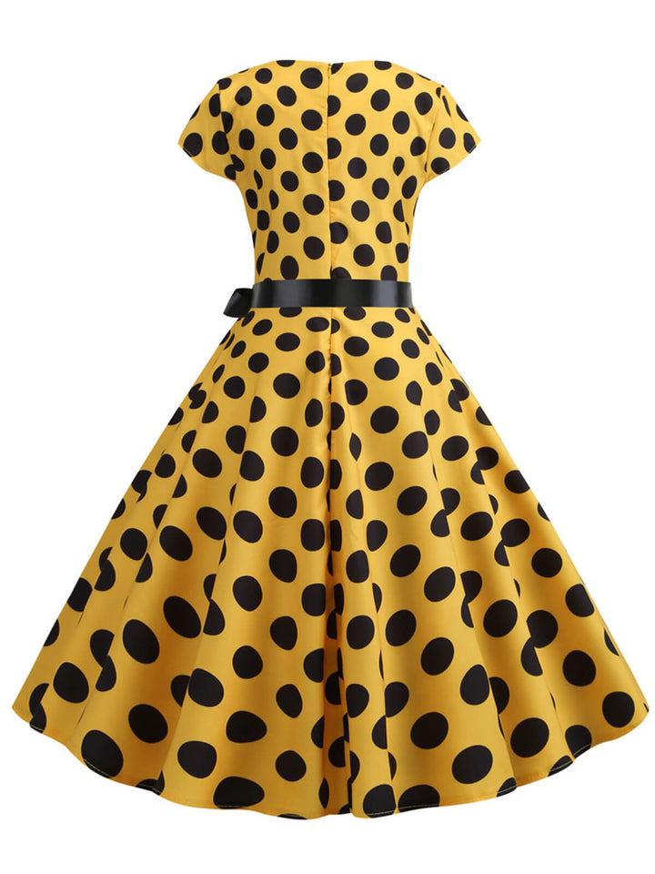 This 1950s Polka Dot Cap Sleeved Dress wraps her in 1950s elegance, one twirl at a time