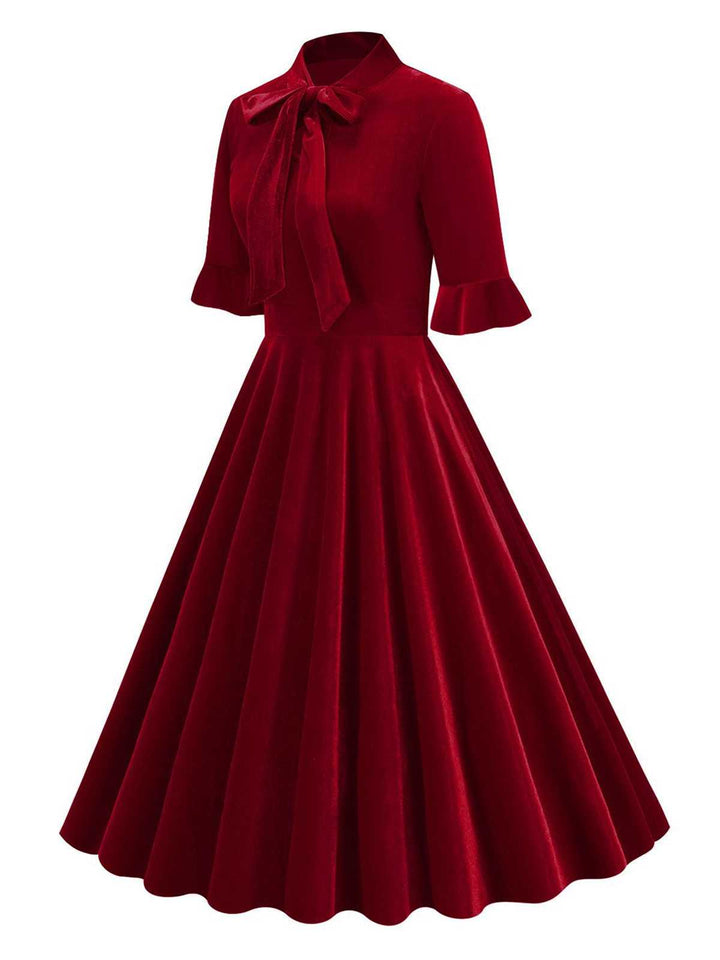 She slips into this 1950s Tie Neck Velvet Flared S