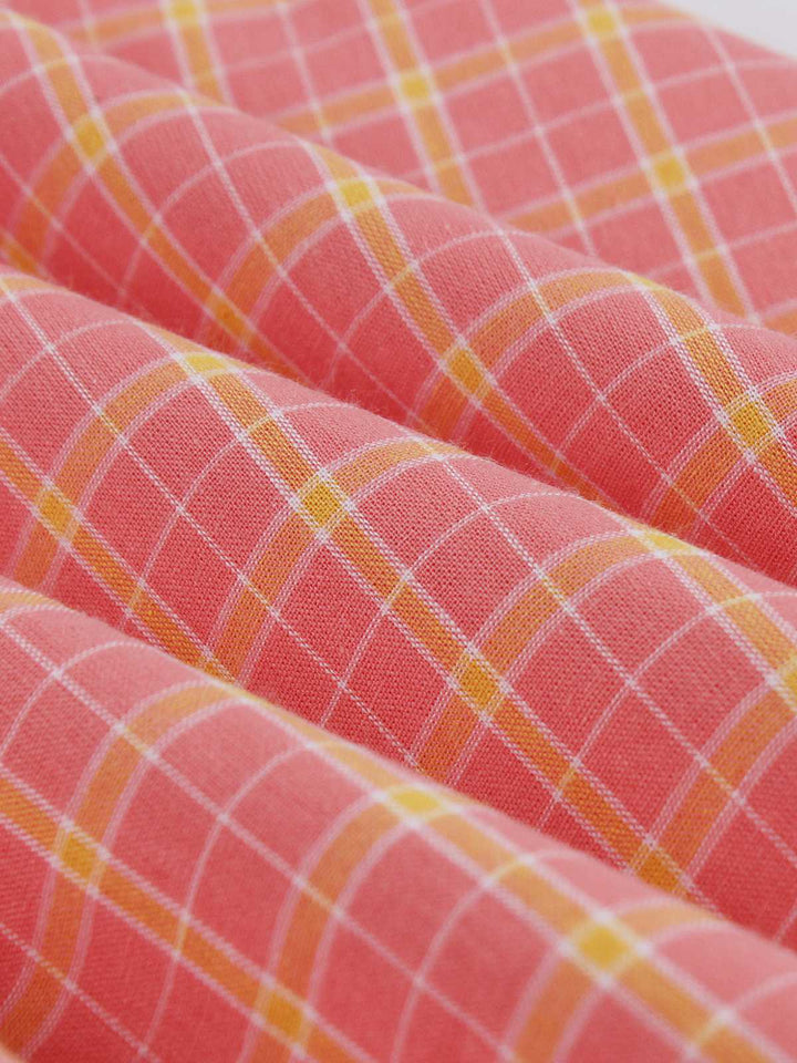 She slips into this Pink 1950s Plaid Buttoned Lapel Belted Dress and suddenly it&